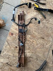Airbag mounting rail under passenger seat